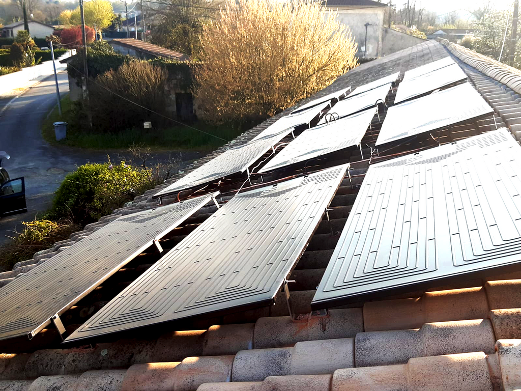 Installation de panneaux solaires sur une toiture en tuiles.