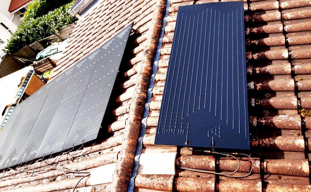 Installation de panneaux solaires sur une toiture en tuiles.
