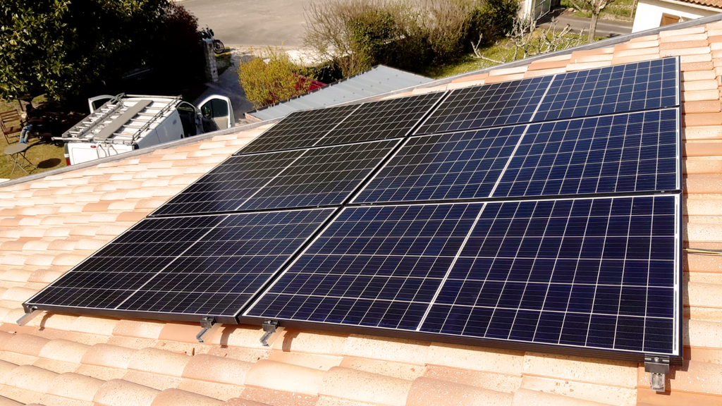 Installation de panneaux solaires sur une toiture en tuiles.