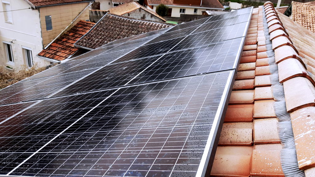 Installation de panneaux solaires sur une toiture en tuiles.
