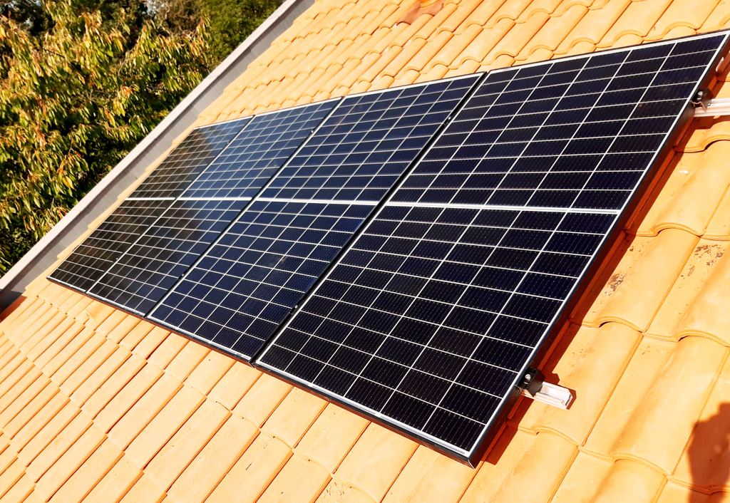 Installation de panneaux solaires sur une toiture en tuiles.