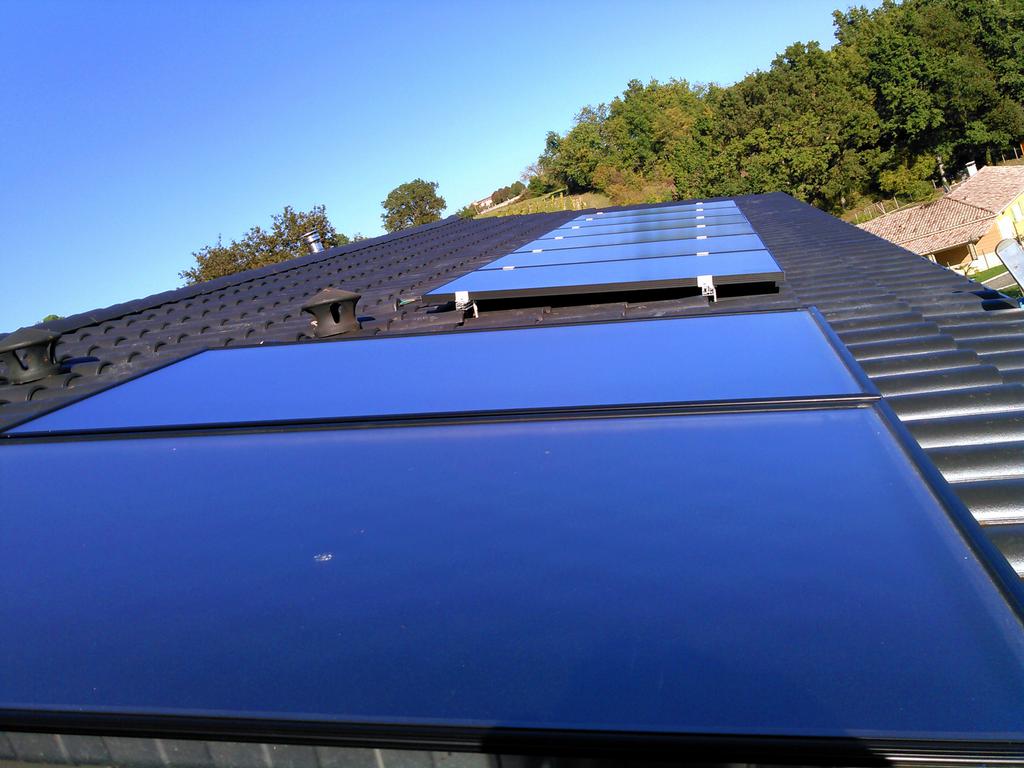 Vue a&eacute;rienne d'une installation de panneaux solaires sur une toiture en bac acier.