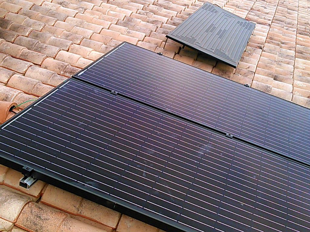 Installation de panneaux solaires sur une toiture en tuiles.
