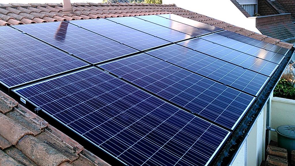 Installation de panneaux solaires sur une toiture en tuiles.