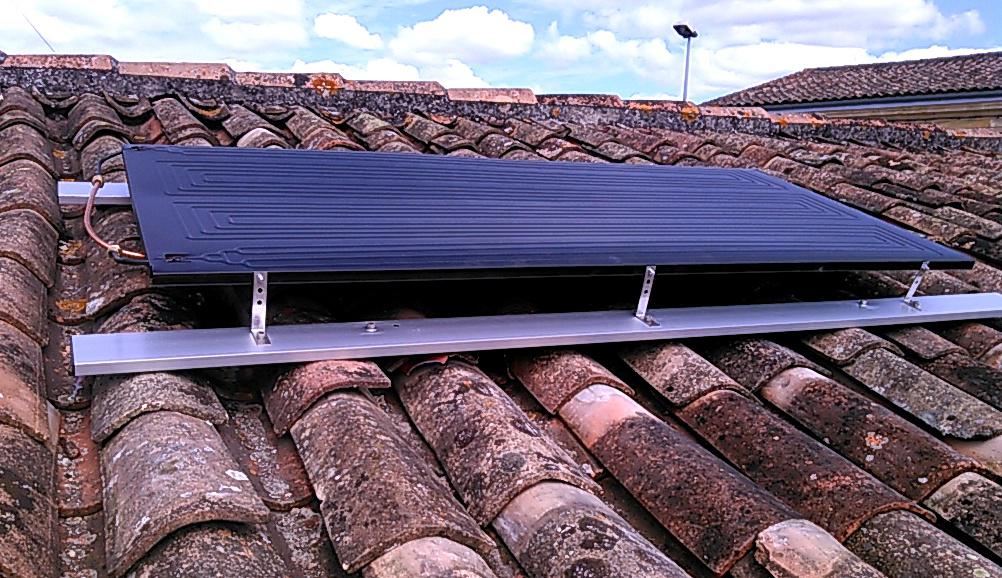Installation de panneaux solaires sur une toiture en tuiles.