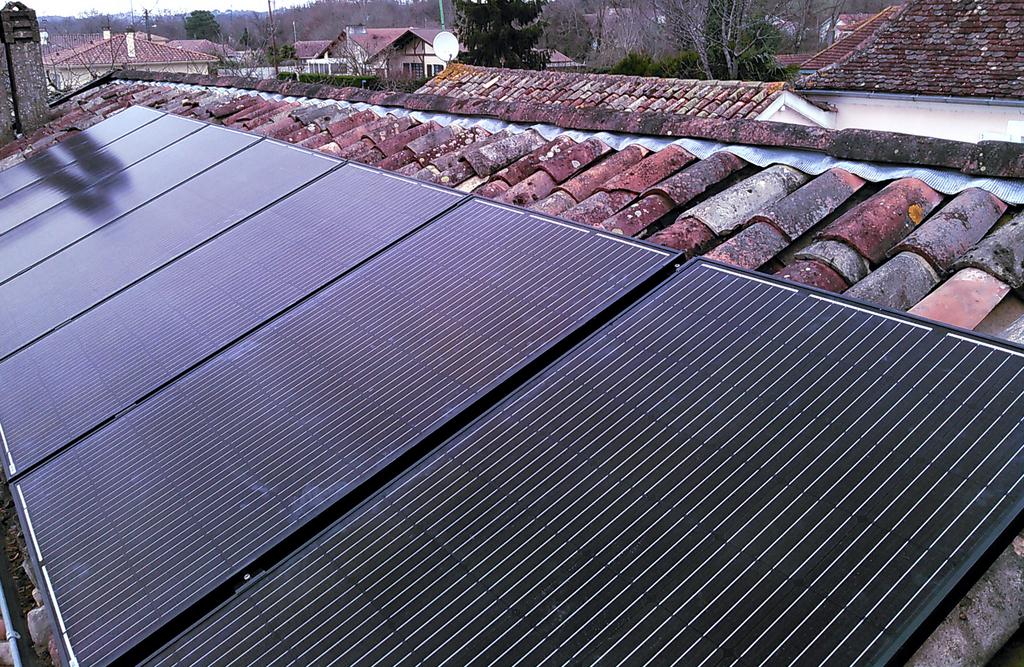 Installation de panneaux solaires sur une toiture en tuiles.