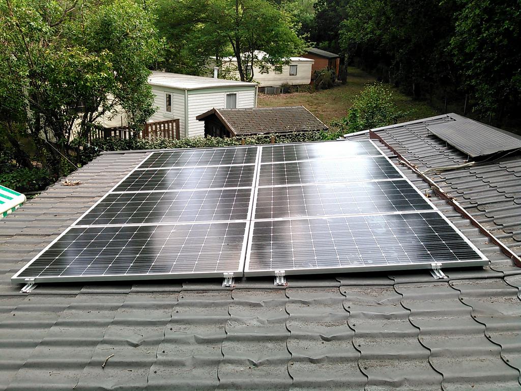 Installation de panneaux solaires sur une toiture en tuiles.