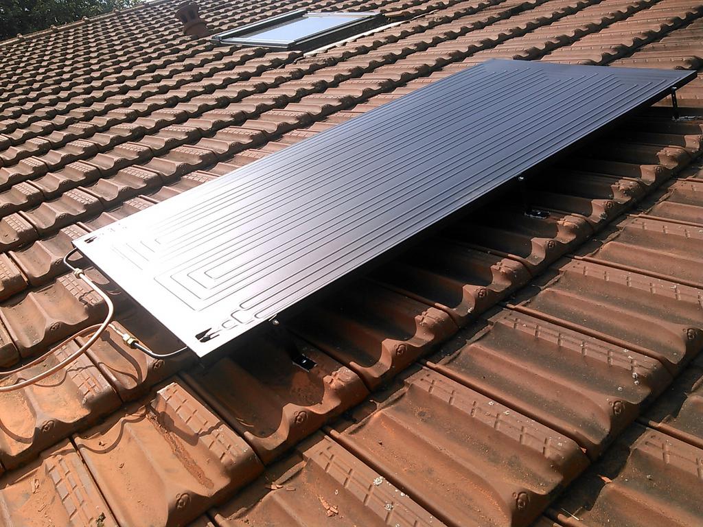 Installation de panneaux solaires sur une toiture en tuiles.
