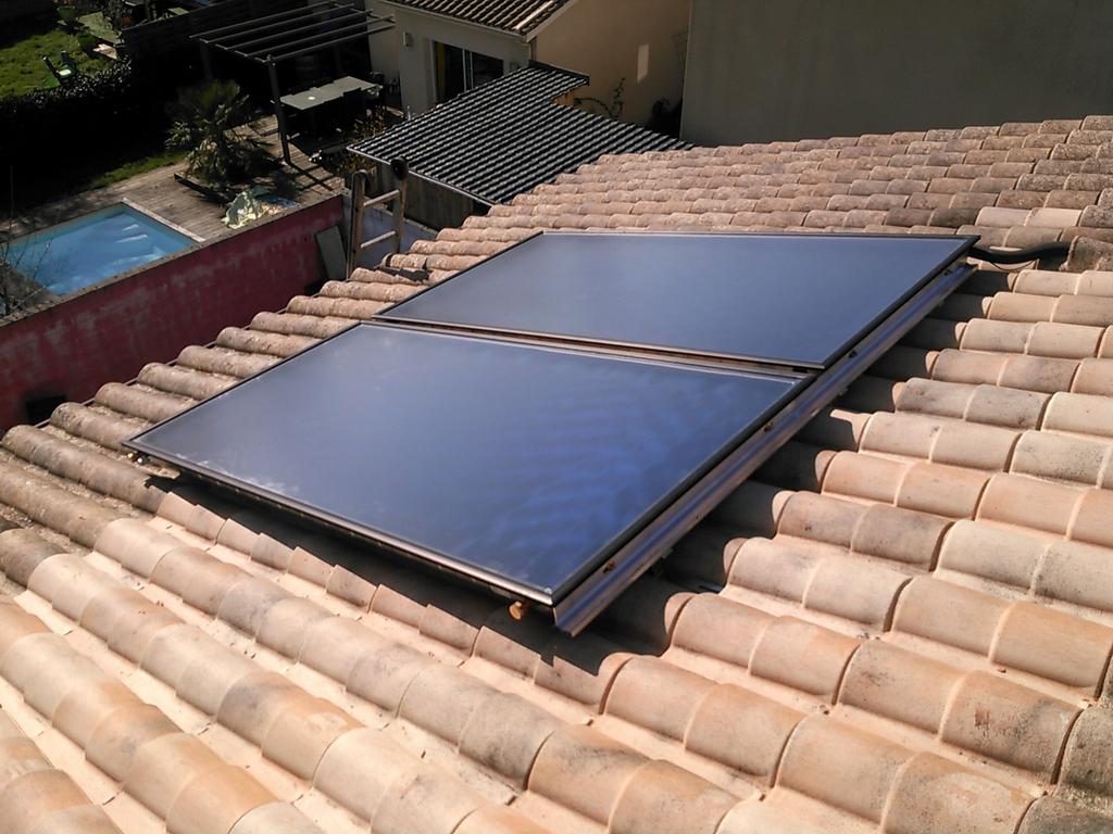 Installation de panneaux solaires sur une toiture en tuiles.