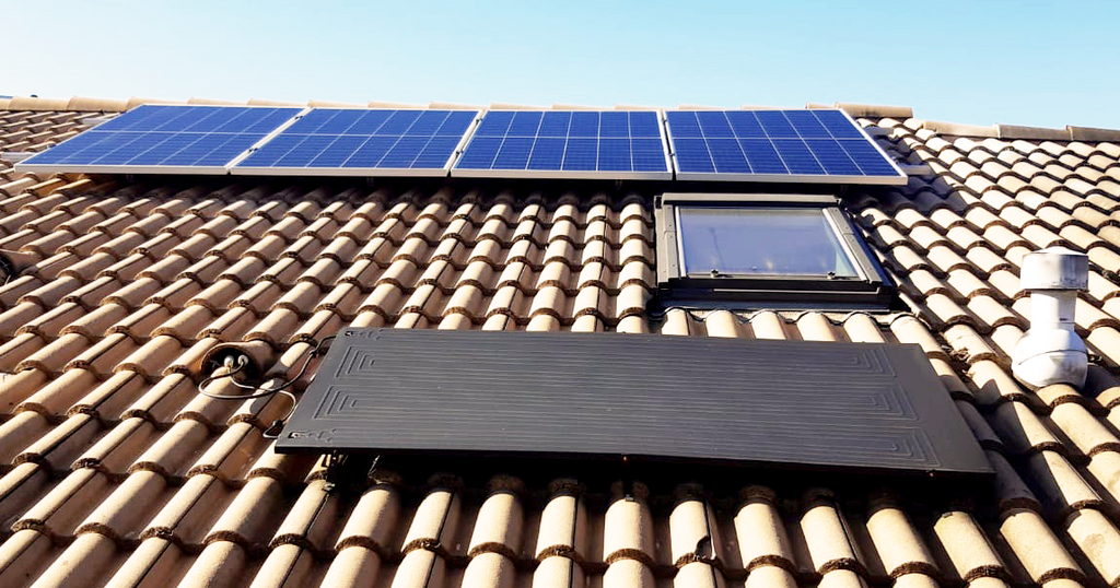 Installation de panneaux solaires sur une toiture en tuiles.